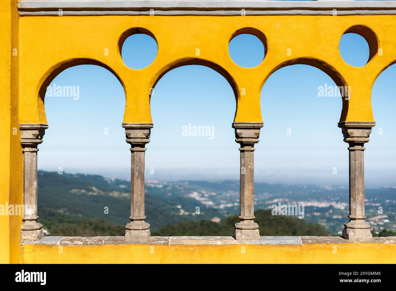Cortile degli archi di Palácio da pena Sintra Portogallo // SINTRA, Portogallo - il cortile degli archi di Palácio da pena mette in mostra elementi architettonici moreschi all'interno di questo palazzo romanticista del XIX secolo. Il cortile ad arco fa parte del Palácio da pena, che fu costruito nel 1840 sulle rovine di un monastero medievale nei Monti Sintra. Il palazzo è una delle sette meraviglie del Portogallo ed è situato all'interno del paesaggio culturale di Sintra, dichiarato patrimonio dell'umanità dall'UNESCO nel 1995. Il Palácio da pena fu commissionato da re Ferdinando II e rappresenta uno dei più bei esempi d'Europa Foto Stock