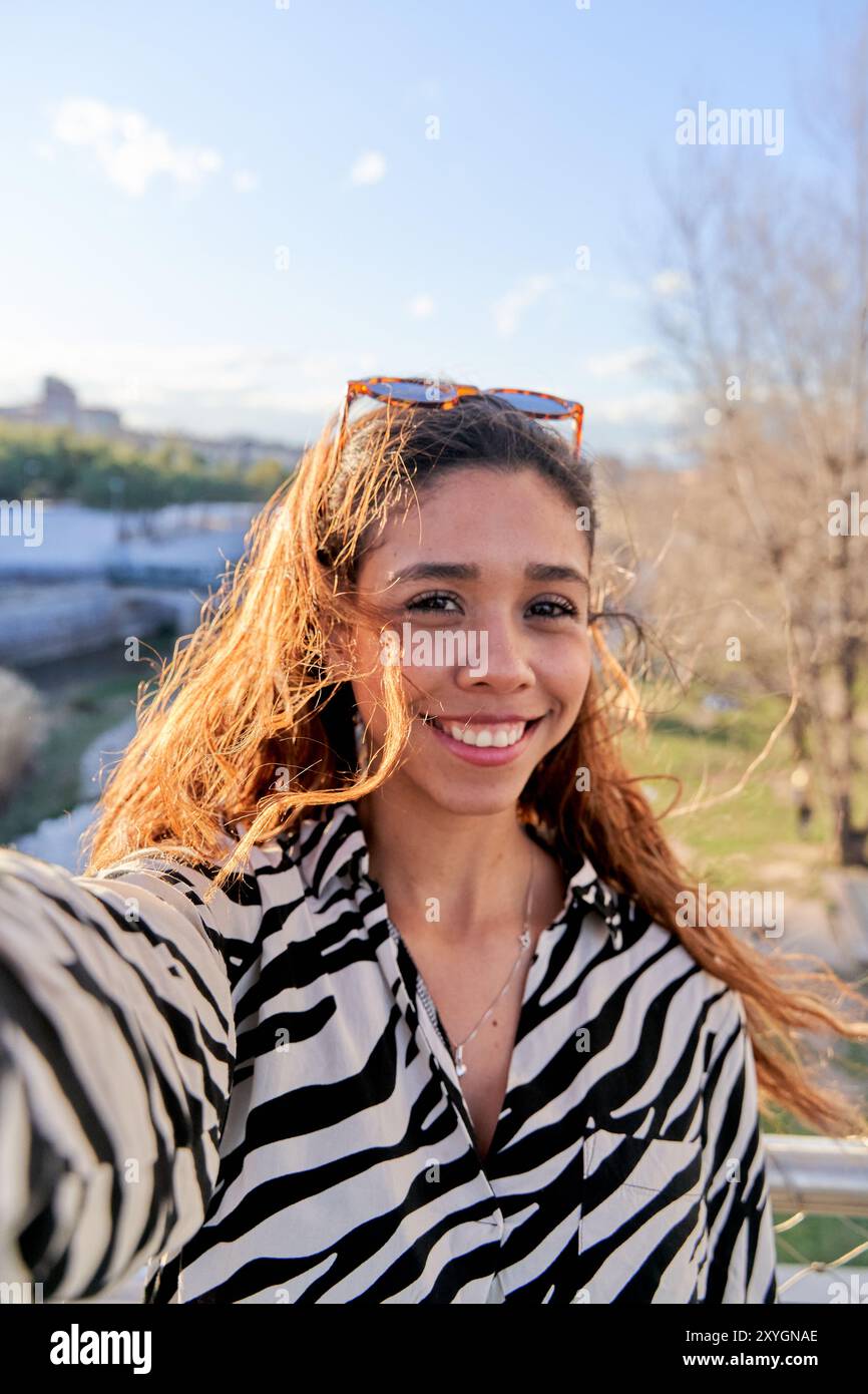 adolescente sorridente che scatta un autoritratto con lo smartphone Foto Stock