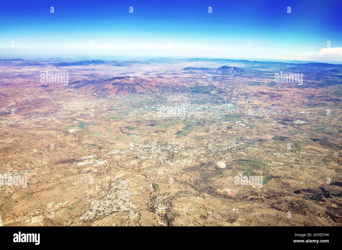 Vista aerea di città del Messico Urban Sprawl Messico // CITTÀ DEL MESSICO, Messico - una vista aerea di città del Messico che si estende attraverso il lago asciutto della Valle del Messico. Il fitto paesaggio urbano si estende all'orizzonte, illustrando l'enorme scala della città e il suo precario rapporto con le risorse idriche. La visibile mancanza di corpi idrici superficiali mette in evidenza la crisi idrica in corso che sta affrontando questa megalopoli costruita sul sito dell'antica capitale azteca di Tenochtitlan. Foto Stock