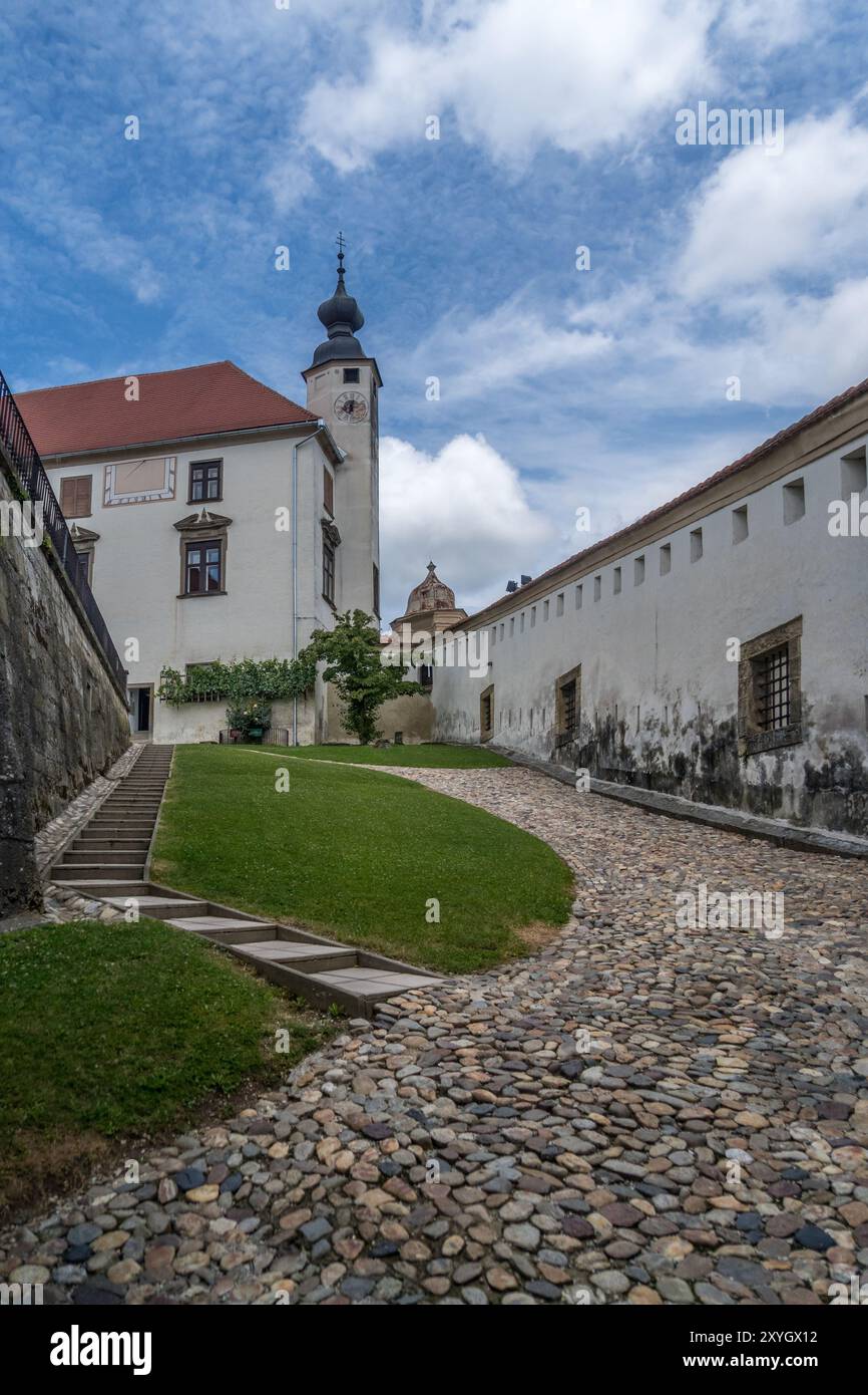 All'interno del castello di Ptuj in Slovenia, cancello restaurato, torre della chiesa, pavimentazione in ciottoli Foto Stock