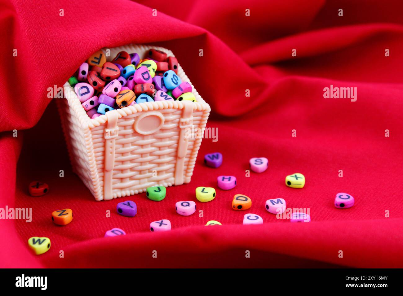 Cestino pieno di cuori colorati con lettere Foto Stock