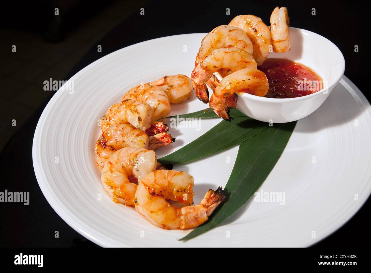 Antipasto per cocktail di gamberi con frittelle su un piatto bianco con una ciotola di salsa cocktail Foto Stock