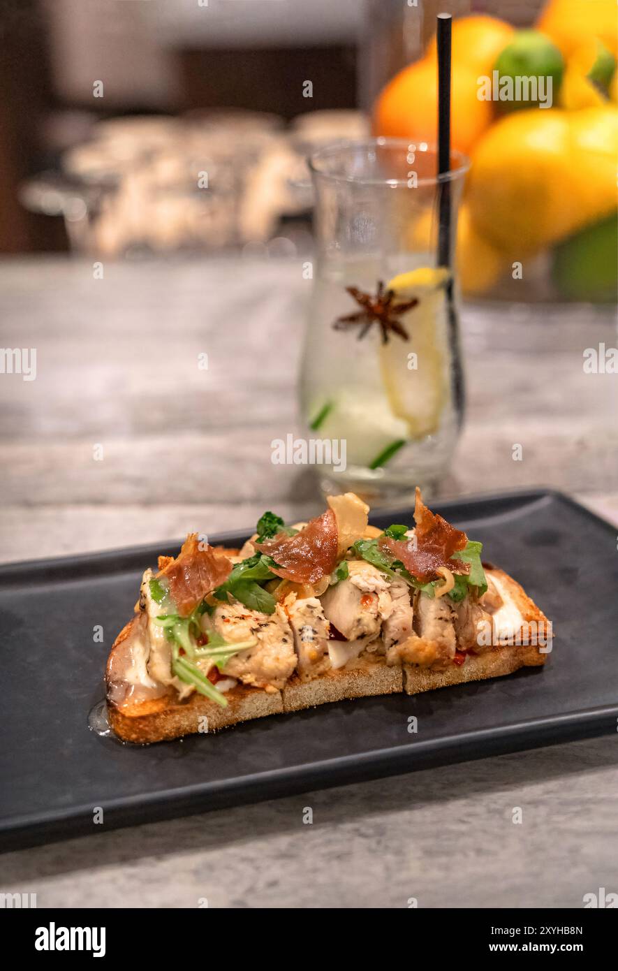 Pollo, prosciutto e formaggio con toast e cocktail tonico al bar Foto Stock