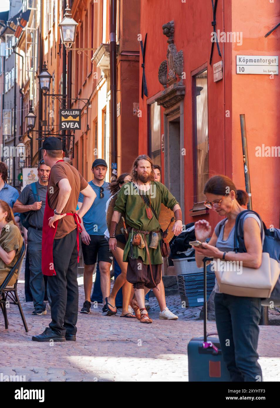 Tour guidato in abbigliamento vichingo a Köpmangatan, Gamla Stan, Stoccolma, Svezia, con architettura medievale e attività di strada. Foto Stock