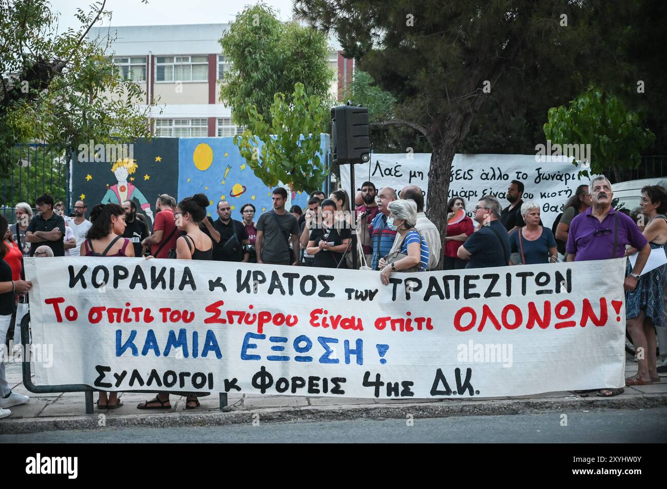 Atene, Grecia. 29 agosto 2024. I manifestanti hanno uno striscione che recita "la casa di Spyros è la casa di tutti noi. Nessuna preclusione domestica” durante una protesta contro uno sfratto familiare dalla loro casa a causa di preclusioni di proprietà. I manifestanti incolpano le banche i fondi e il governo greco per crudeltà, mentre affermano che la famiglia che non può rimborsare il loro mutuo ha un figlio disabile. Il paese si trova di fronte a un peggioramento della carenza di alloggi che è diventato un grave problema sociale, rendendolo estremamente inaccessibile per le famiglie comuni. Crediti: Dimitris Aspiotis/Alamy Live News Foto Stock