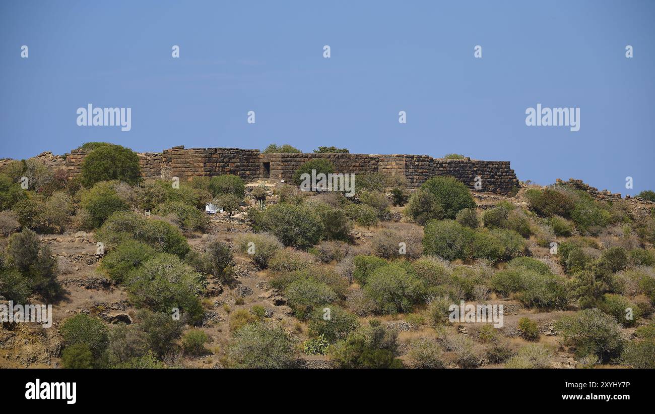 Antiche mura in rovina in un paesaggio arido sotto un cielo blu con bassa vegetazione, Palaiokastro, antica fortezza, III e IV secolo a.C., sopra Mandraki, Foto Stock