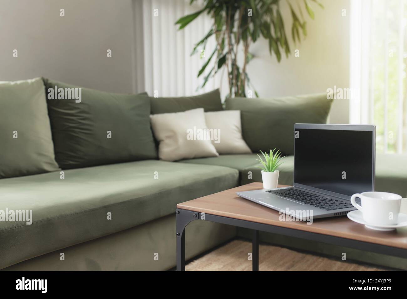 Lavoro da casa, spazio di lavoro, desktop, concetto di lavoro remoto, computer portatile grigio sottile con schermo nero vuoto su tavolo di legno marrone con tazza bianca di cof Foto Stock