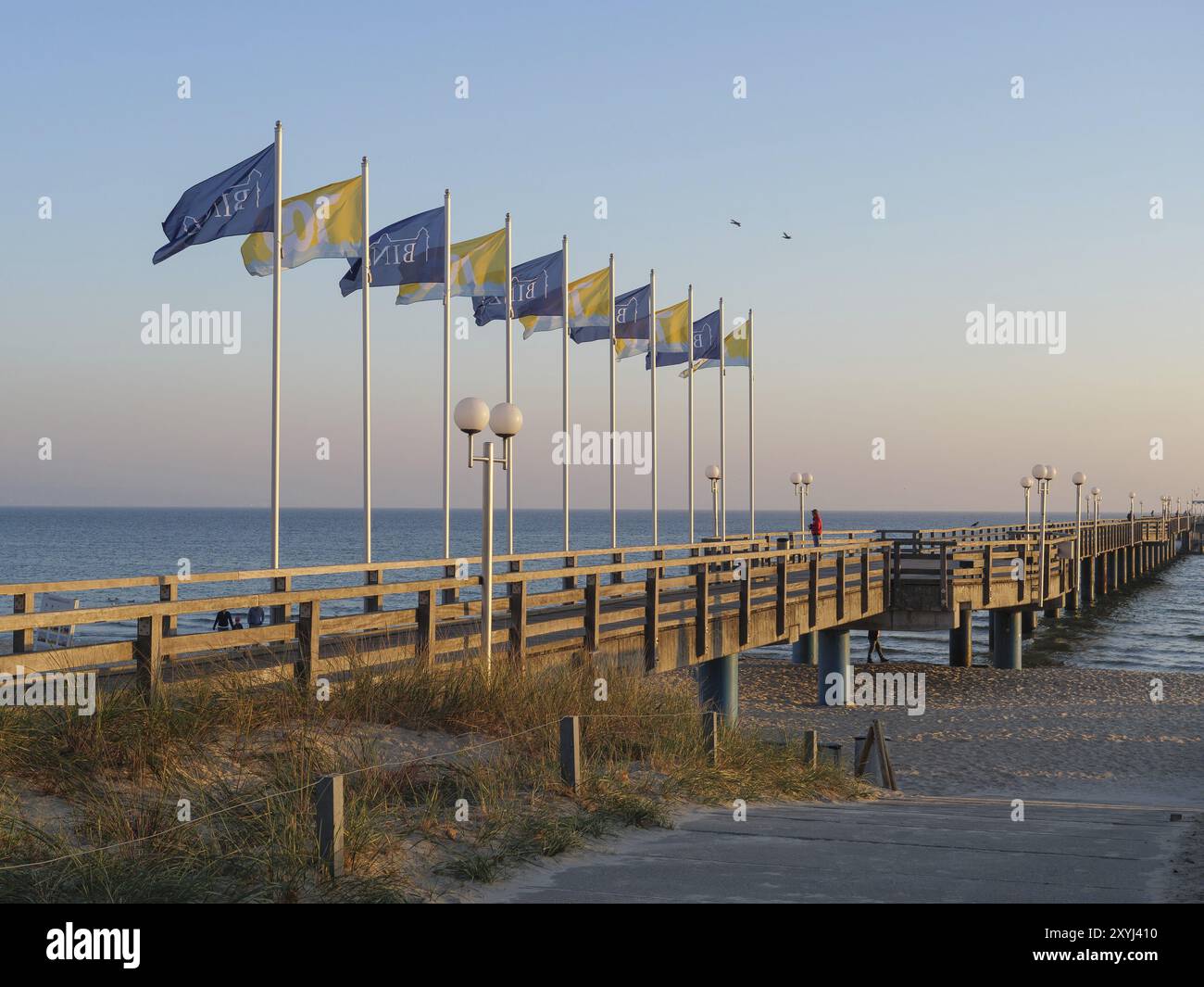 Una lunga passerella in legno con bandiere ondulate e lanterne allineate al crepuscolo, binz, ruegen, Mar baltico, germania Foto Stock