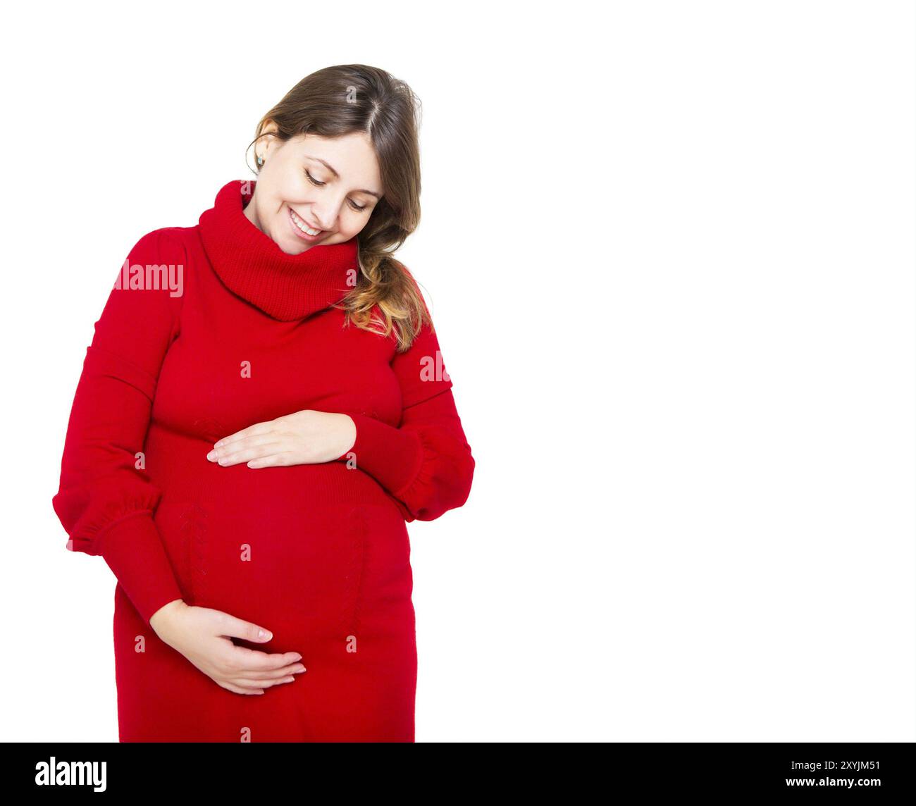 Felice giovane donna incinta in abito rosso toccando il suo ventre Foto Stock