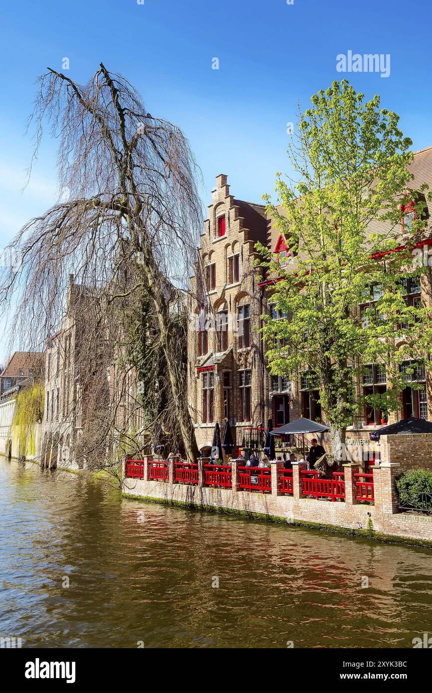 Bruges, Belgio, 10 aprile 2016: Paesaggio urbano panoramico con case medievali, caffè e canale a Bruges, Europa Foto Stock