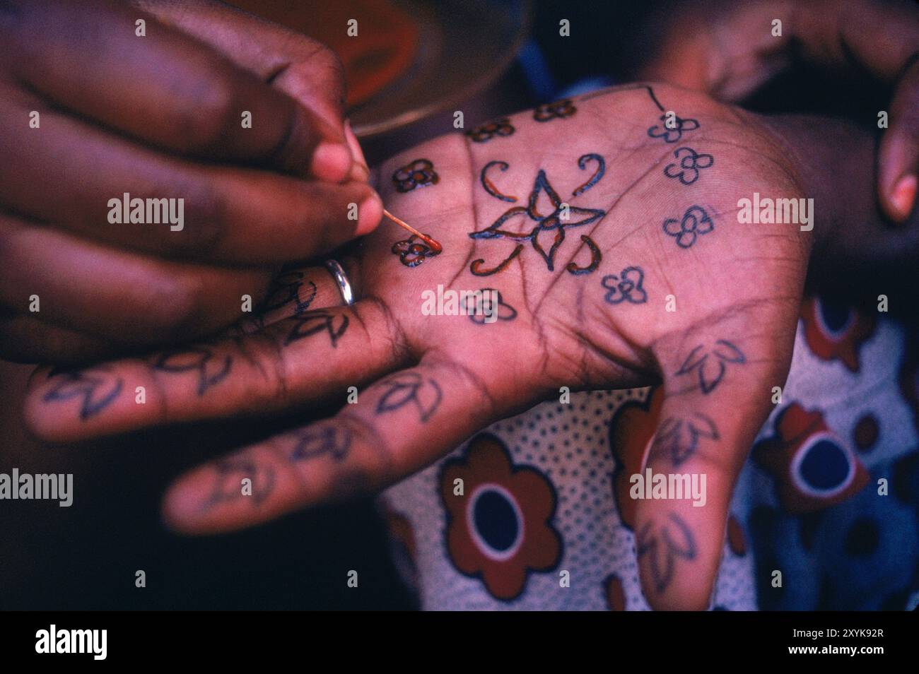 La mano della donna swahili è dipinta con un intricato design all'henné. Foto Stock