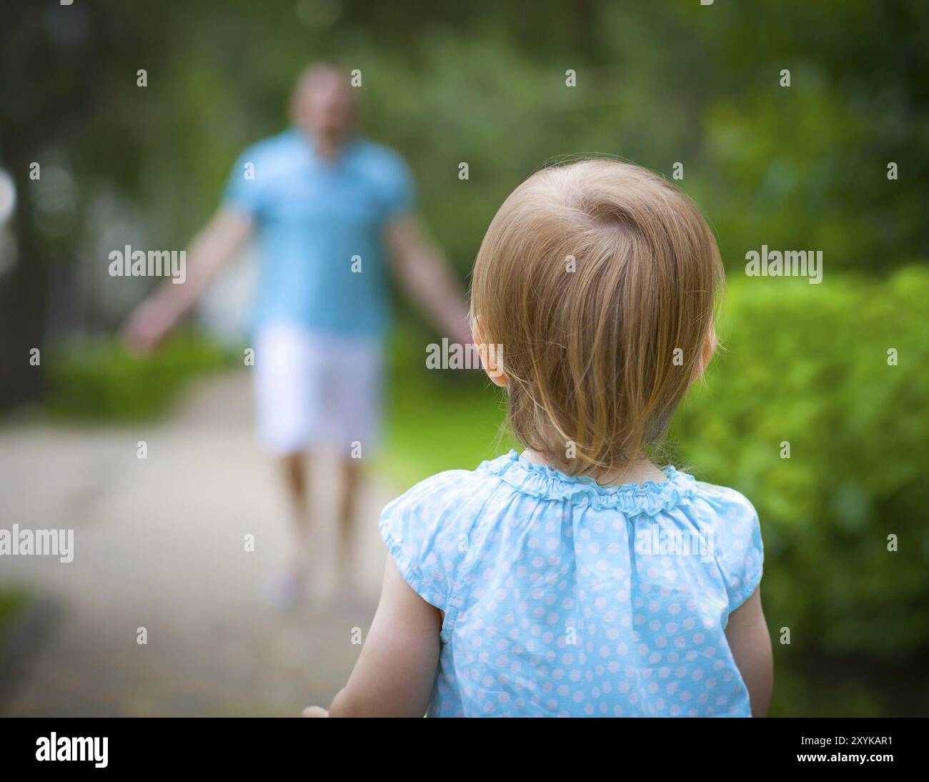 Felice giovane padre con piccola figlia all'aperto in estate park. Baby girl in esecuzione al padre Foto Stock