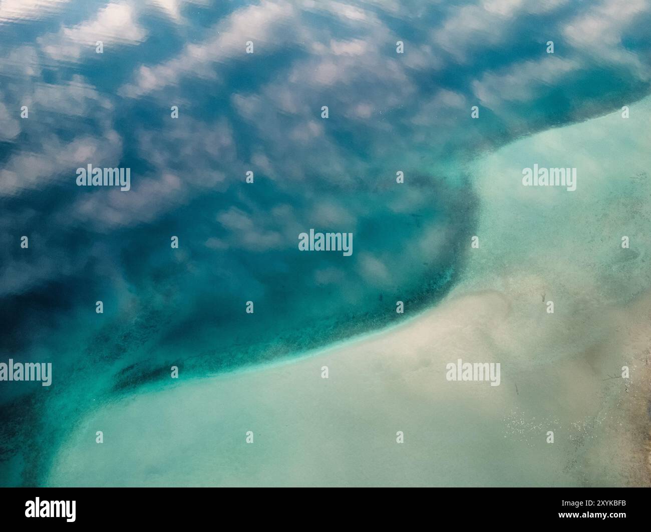 Vista delle nuvole rosa che si riflettono sull'acqua blu del lago dall'alto Foto Stock