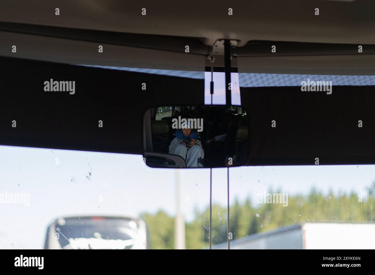 Donna che viaggia in autobus. riflesso nello specchietto retrovisore. Foto Stock