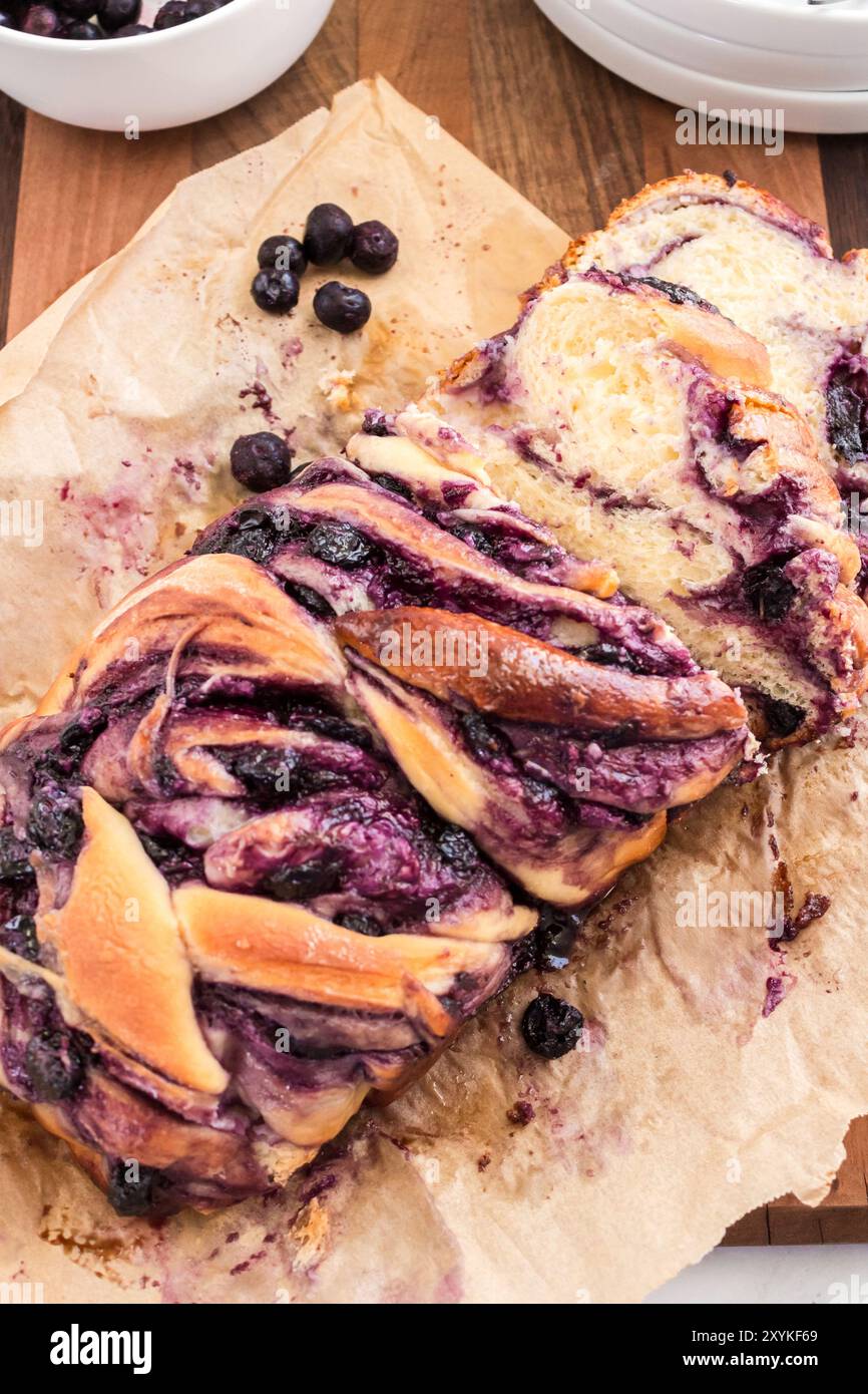 Babka di formaggio cremoso ai mirtilli appena tagliata su carta pergamena Foto Stock