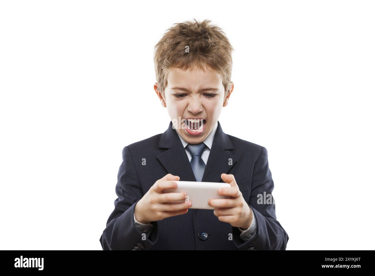 Piccolo bel ragazzo sorridente in abito da lavoro giocare a giochi o navigare su Internet su smartphone digitale computer bianco isolato Foto Stock