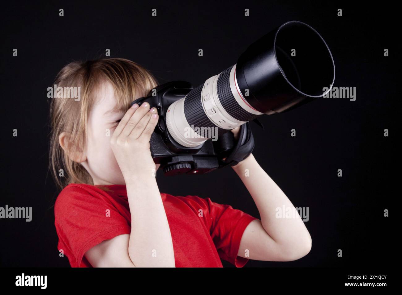 Il bambino, fotografo. Su sfondo nero Foto Stock