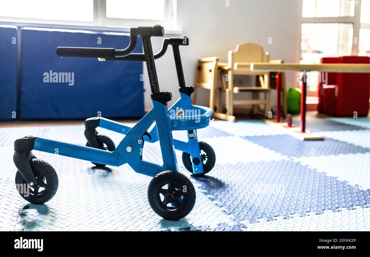 Il dispositivo di mobilità Blue Walker è posizionato in uno spazio terapeutico progettato per le attività di riabilitazione fisica dei bambini Foto Stock