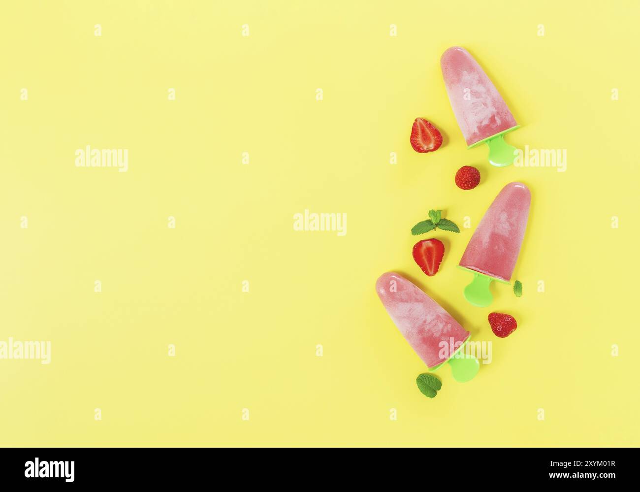 Piatto con gelato al sorbetto congelato rosa fruttato su bastone di plastica verde con tagli di fragola, foglie di menta su sfondo giallo. Congelato Foto Stock
