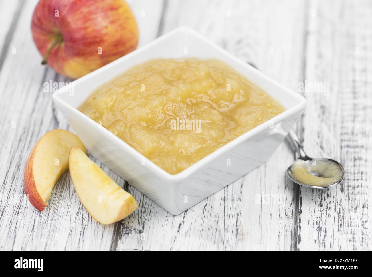 Salsa di mele fatta in casa (messa a fuoco selettiva, foto ravvicinata) su sfondo vintage con frutta fresca Foto Stock