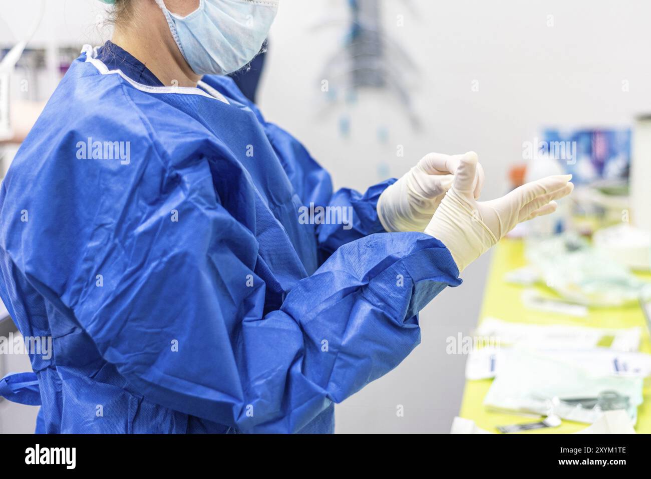 Chirurgo che indossa guanti sterili in sala operatoria Foto Stock