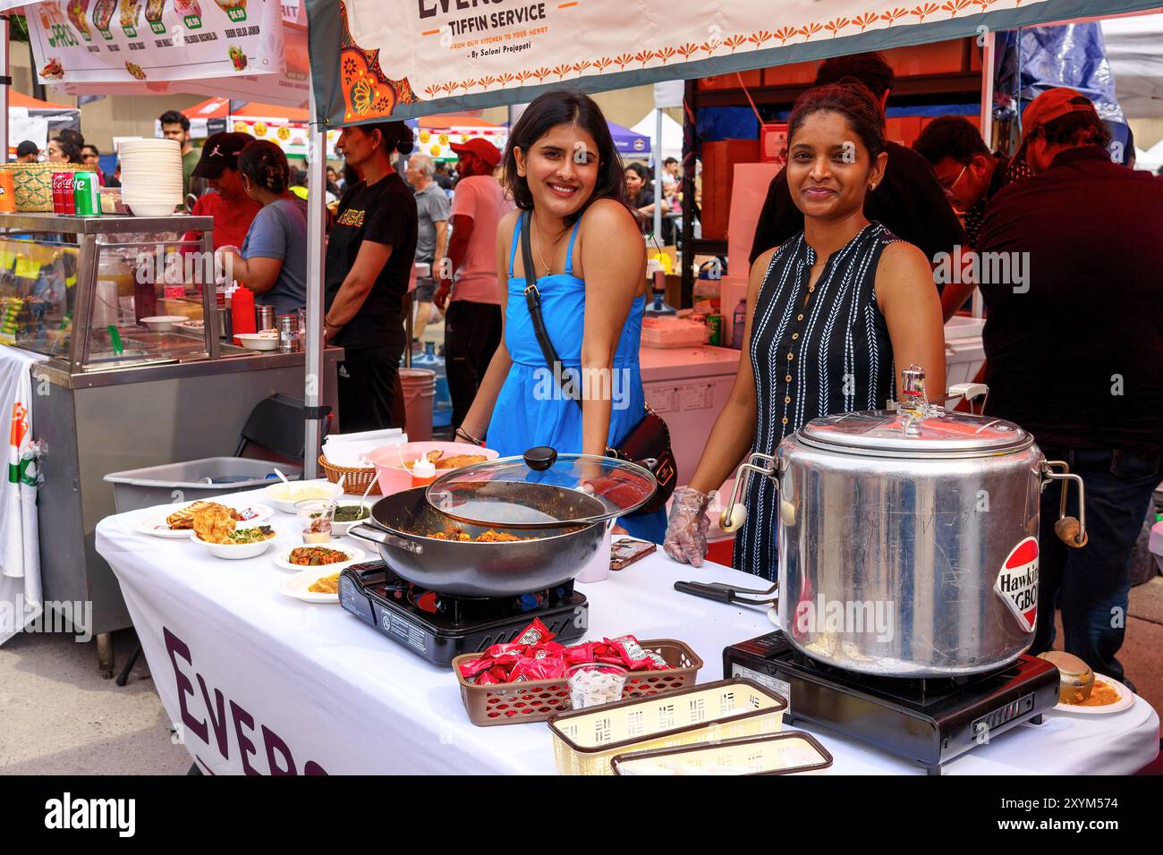 Due giovani donne che vendono cibo in un chiosco durante il festival Taste of India. Foto Stock