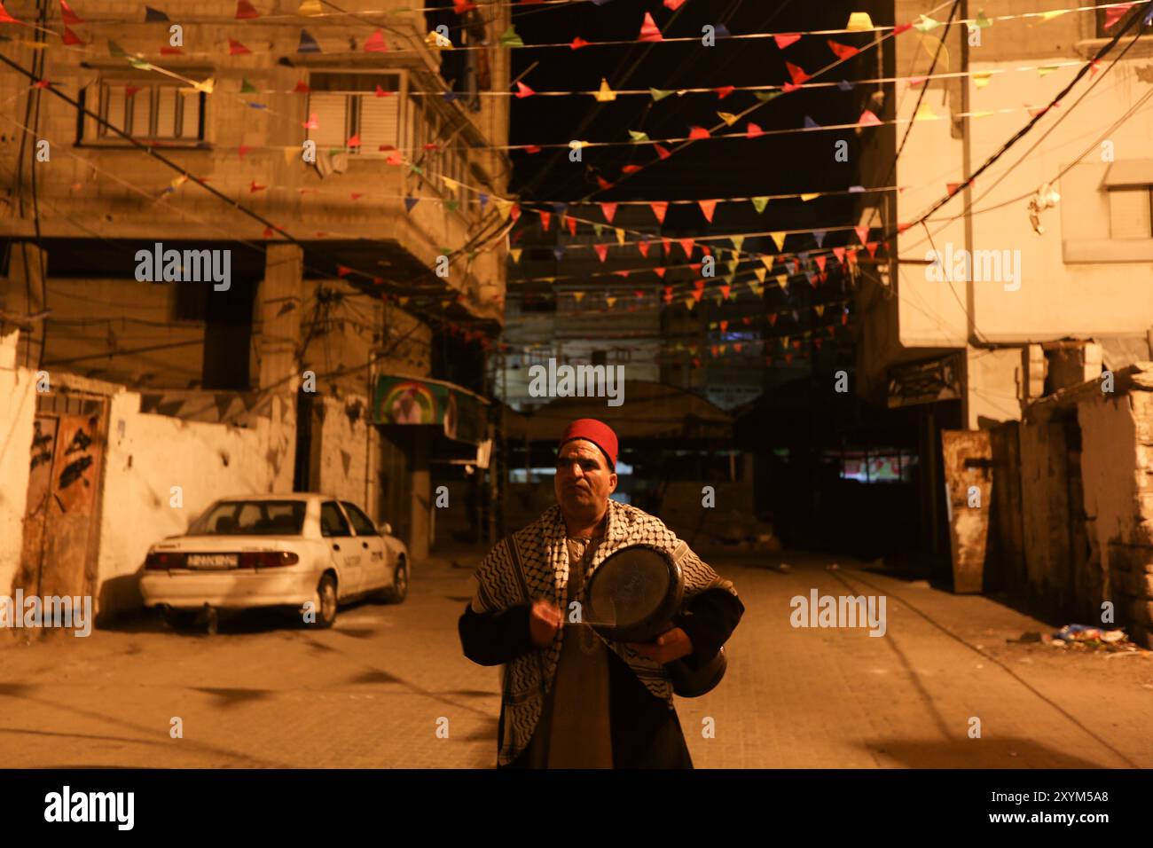 Khan Yunis, Striscia di Gaza, Palestina. 5 aprile 2022. Il palestinese Nizar al-Dabbas vagava per le strade di Khan Younis battendo un tamburo prima dell'alba durante il mese sacro musulmano del Ramadan. La figura del batterista musulmano o “Masaharati” fa parte di una vecchia tradizione con lo scopo di risvegliare i musulmani e ricordare loro il pasto suhoor che precede il digiuno Foto Stock