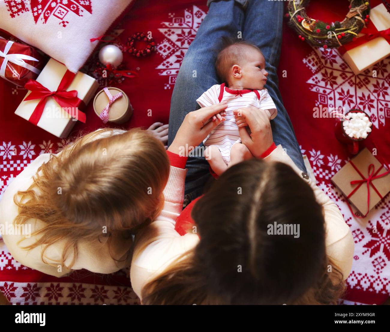 Allegro la mamma e il suo piccolo grazioso figlie lo scambio di doni. Madre e un po' di bambini che si divertono nel tempo di Natale. Vista superiore Foto Stock