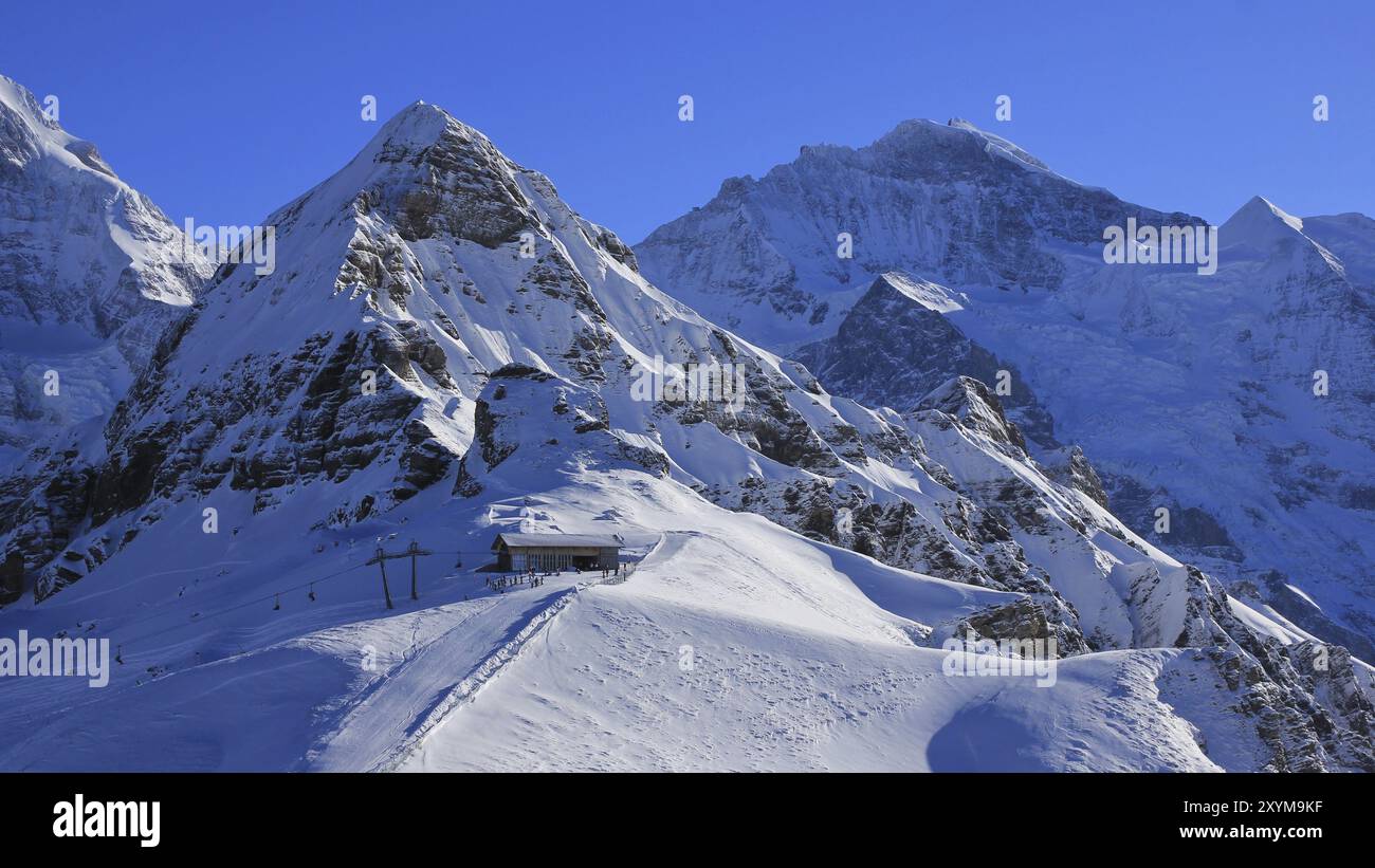 Scena invernale a Grindelwald, Alpi svizzere. Montagne innevate, Lauberhorn e Jungfrau, stazione in cima a una funivia Foto Stock