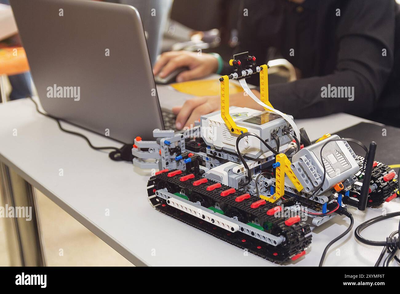 Flusso di lavoro di costruzione di auto elettroniche con microcontrollore presso il club robotico junior. Creazione collettiva di elettronica fai da te, tecnologia moderna Foto Stock