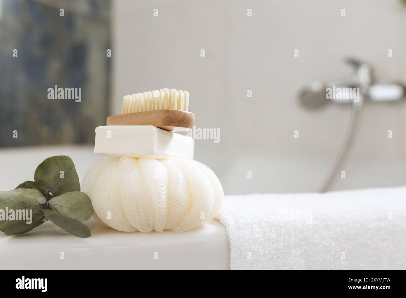 Lavabo in bagno bianco con accessori da bagno. Concetto di pulizia dell'hotel. Concetto domestico. Panno, sapone, spazzola per i piedi, asciugamano e ramo di eucalipto Foto Stock