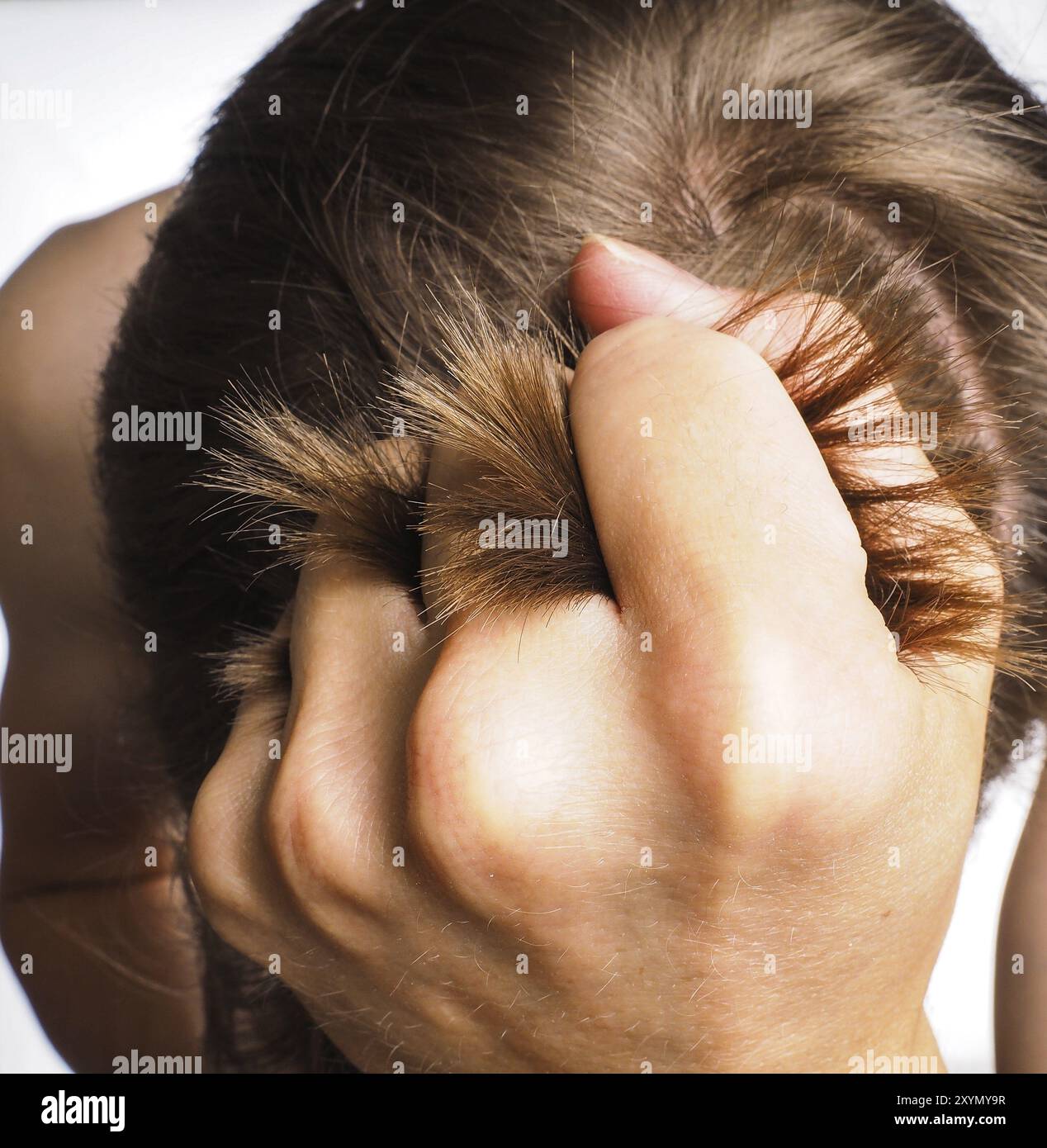 Primo piano della mano che tira i capelli dalla testa di una persona maschile Foto Stock
