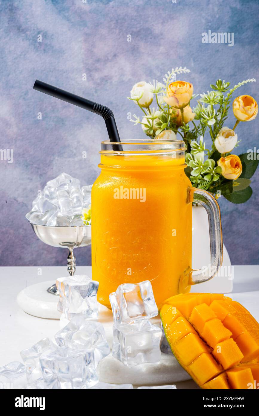 Frullato di mango rinfrescante con panna montata e cubetti di ghiaccio Foto Stock