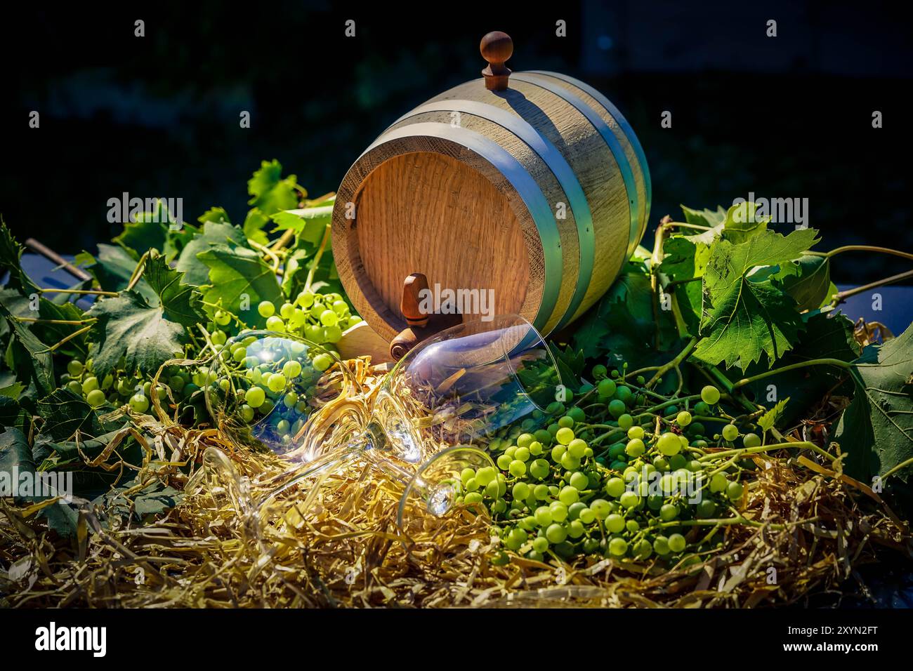 Uva, viti, botte di vino e bicchiere di vino in paglia Foto Stock