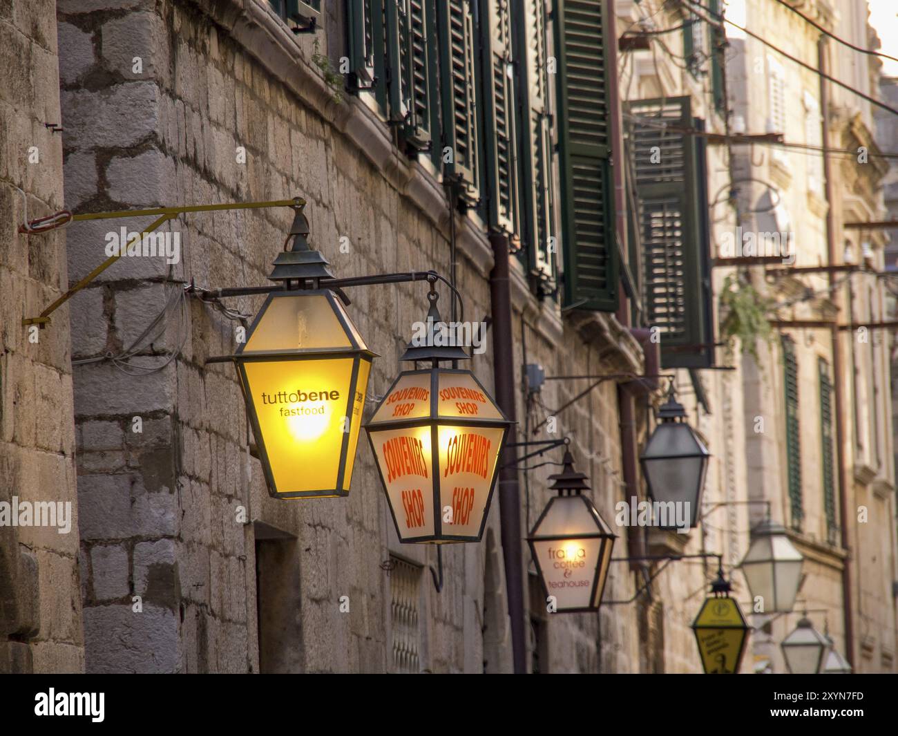 Una strada stretta con tradizionali lanterne e muri in pietra, l'illuminazione serale crea un'atmosfera accogliente, dubrovnik, Mediterraneo, Croazia ed Europa Foto Stock