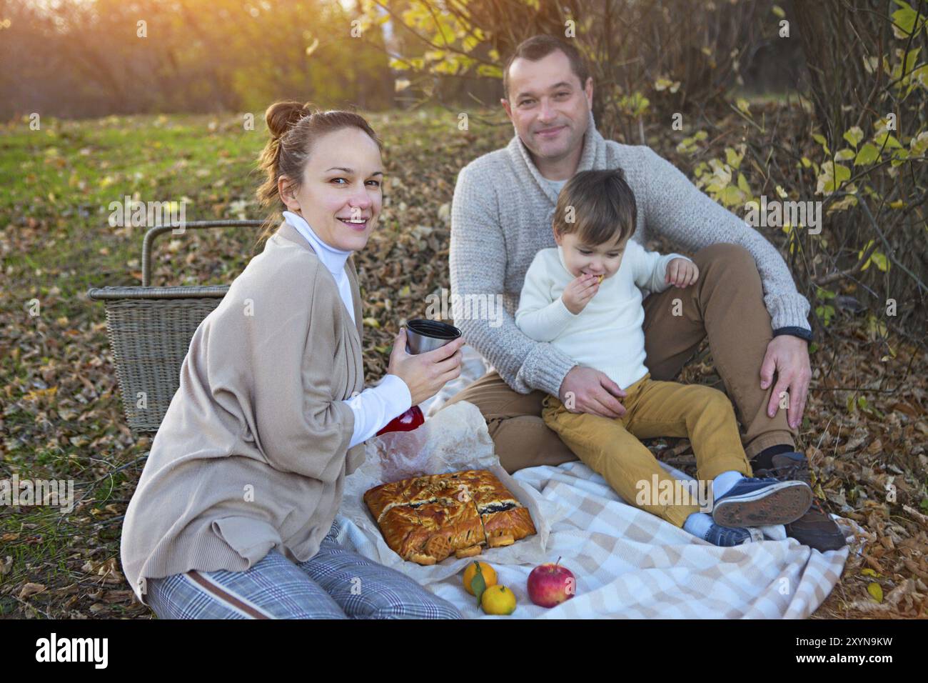 La famiglia felice insieme in autunno picnic in serata Foto Stock