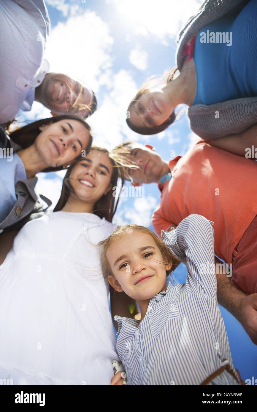 Gruppo di sorridenti amici contro il cielo blu. Basso angolo di visione Foto Stock