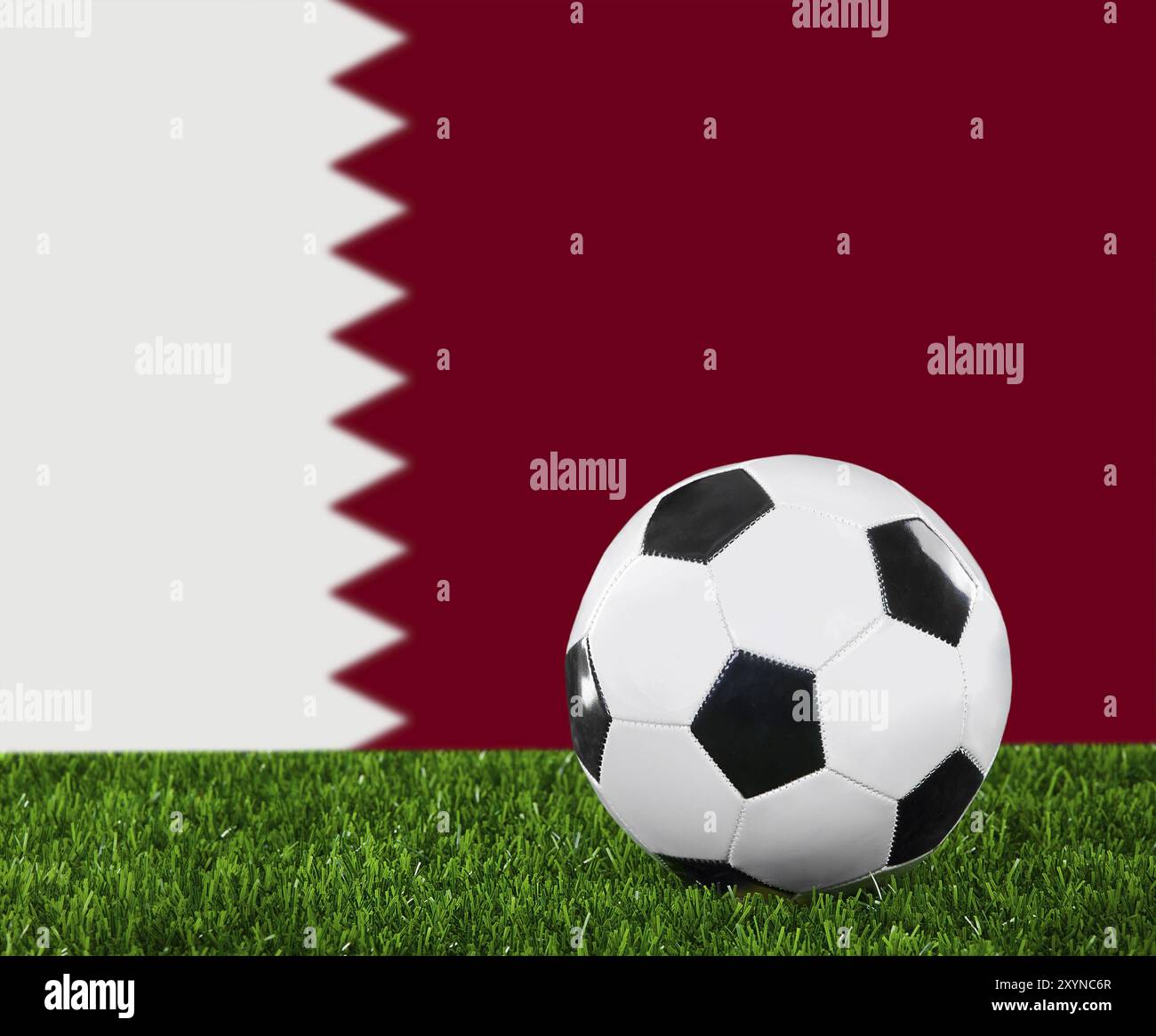 La bandiera del Qatar e la palla da calcio sull'erba verde Foto Stock