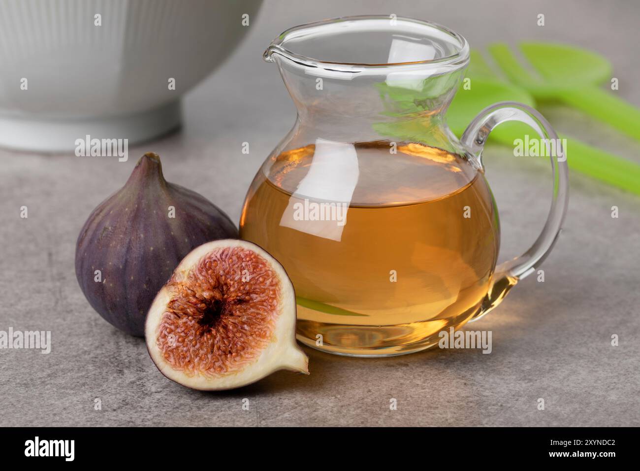 Vaso di vetro con aceto di fichi fatto in casa e fichi freschi da vicino come ingrediente Foto Stock