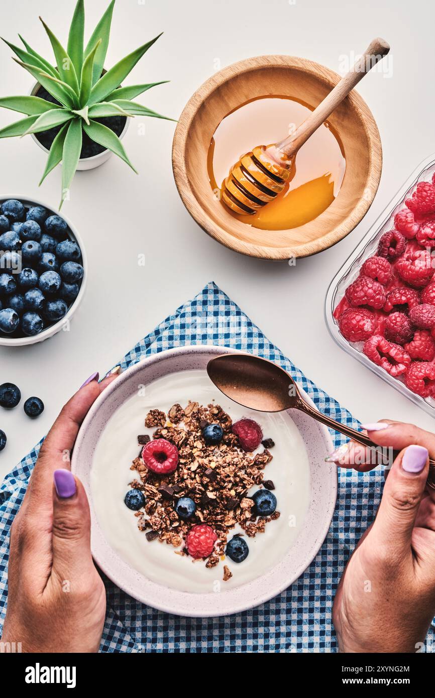 Colazione salutare. Yogurt con muesli, frutti di bosco e vista dall'alto sul miele Foto Stock