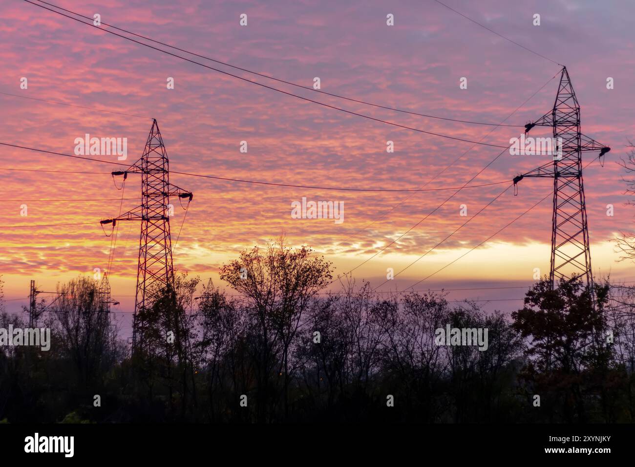 Linee elettriche ad alta tensione al tramonto. In futuro - ​​scarcity di elettricità. A causa dei prezzi elevati, le persone disperate non hanno soldi per pagare l'elettricità Foto Stock