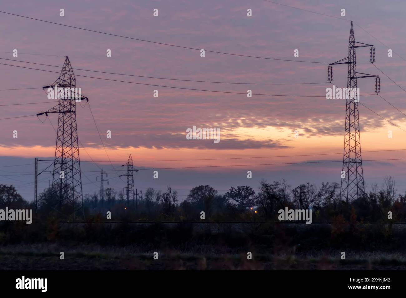 Linee elettriche ad alta tensione al tramonto. In futuro - ​​scarcity di elettricità. A causa dei prezzi elevati, le persone disperate non hanno soldi per pagare l'elettricità Foto Stock