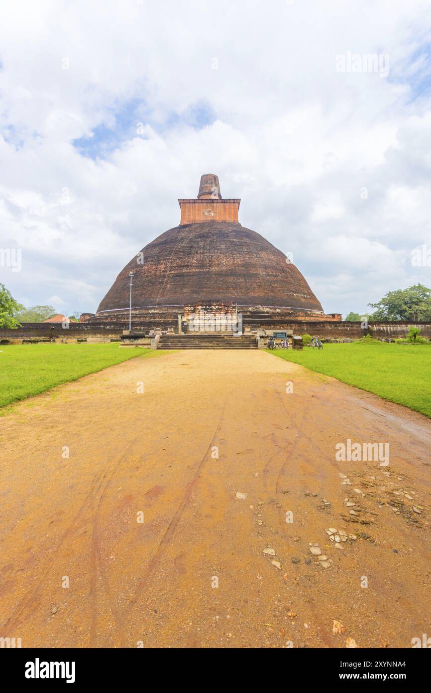 Strada sterrata che conduce al centro di Jetavanaramaya Dagoba o rovine di stupa in una splendida giornata di cielo blu nell'antica capitale del Regno di Anuradhapura nello Sri Lanka Foto Stock