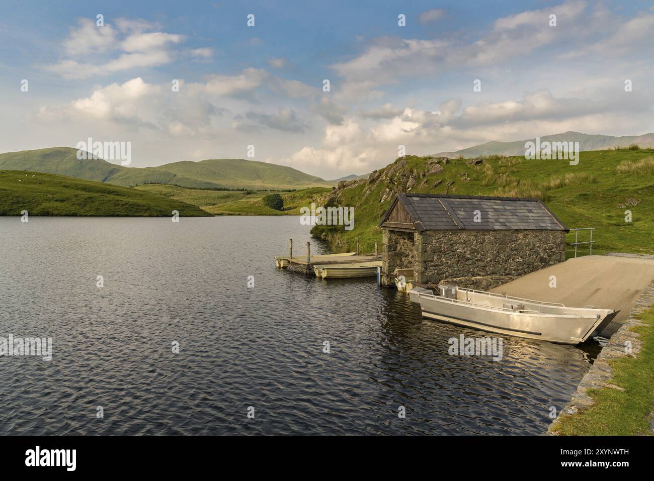 Barche e casetta di barche a Llyn y Dywarchen vicino a Rhyd DDU a Gwynedd, Galles, Regno Unito, con il Monte Snowdon sullo sfondo Foto Stock