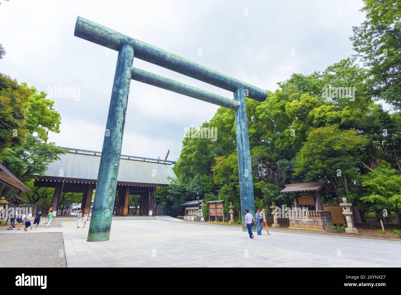 Tokyo, Giappone, 30 luglio 2015: Persone che camminano attraverso la porta angolata di Daini Torii fino alla porta di legno shinmon all'ingresso del controverso santuario shintoista Yasukuni Foto Stock