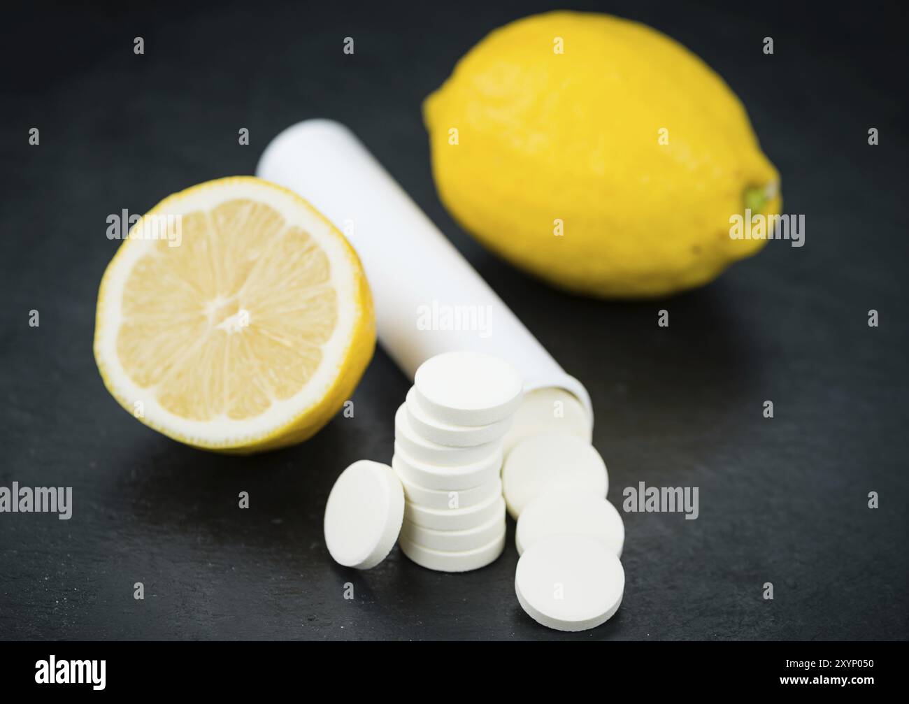 Alcune compresse di vitamina C su una lastra di ardesia come foto ravvicinata dettagliata, messa a fuoco selettiva Foto Stock