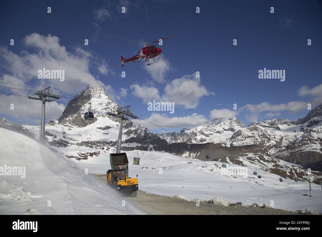 Zermatt, Svizzera, 13 aprile 2017: Un elicottero che carica cemento in un cantiere sulle montagne svizzere, in Europa Foto Stock