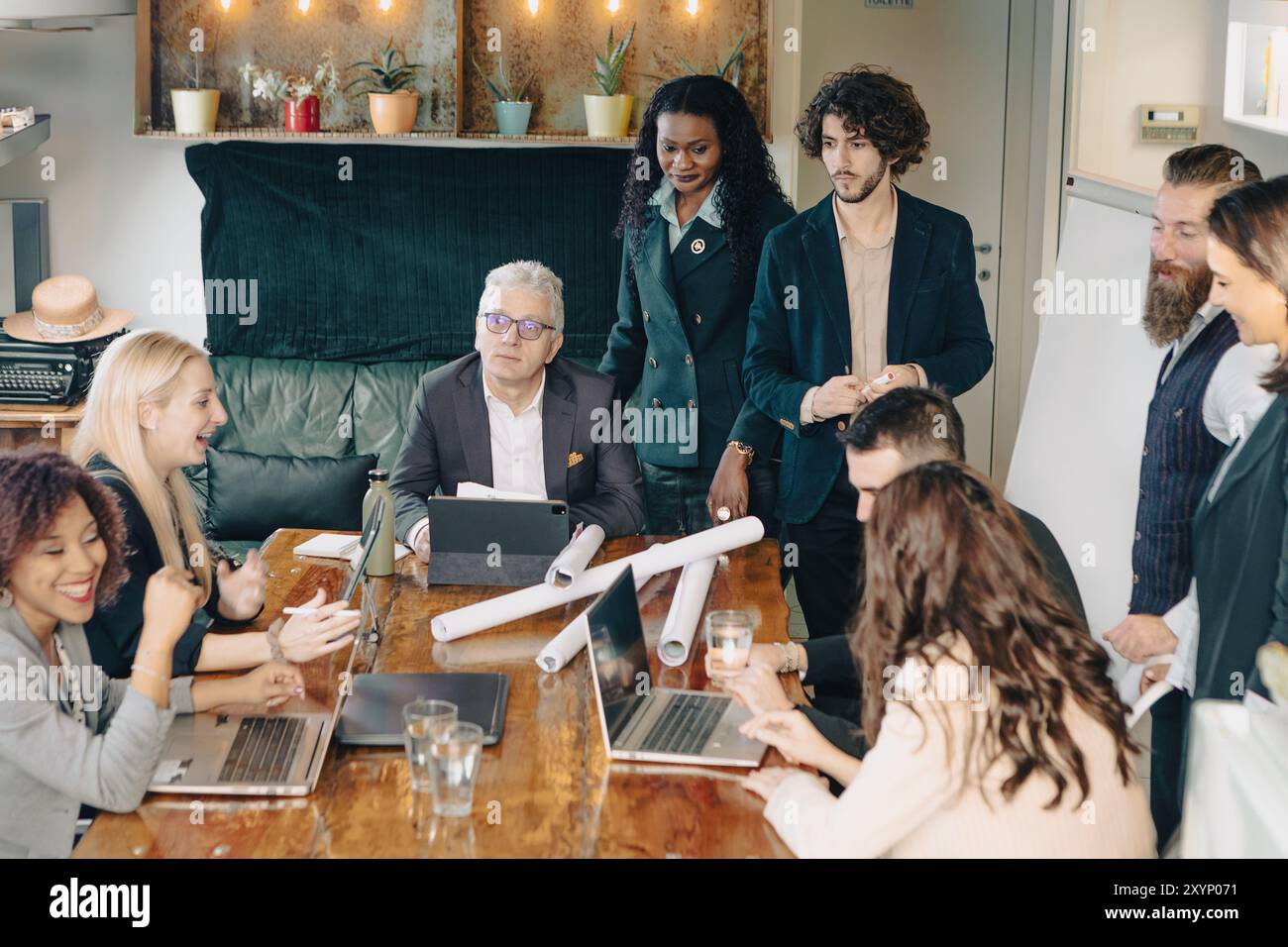 Diversi team di uomini d'affari stanno organizzando riunioni produttive in un ufficio moderno, collaborando e organizzando strategie Foto Stock