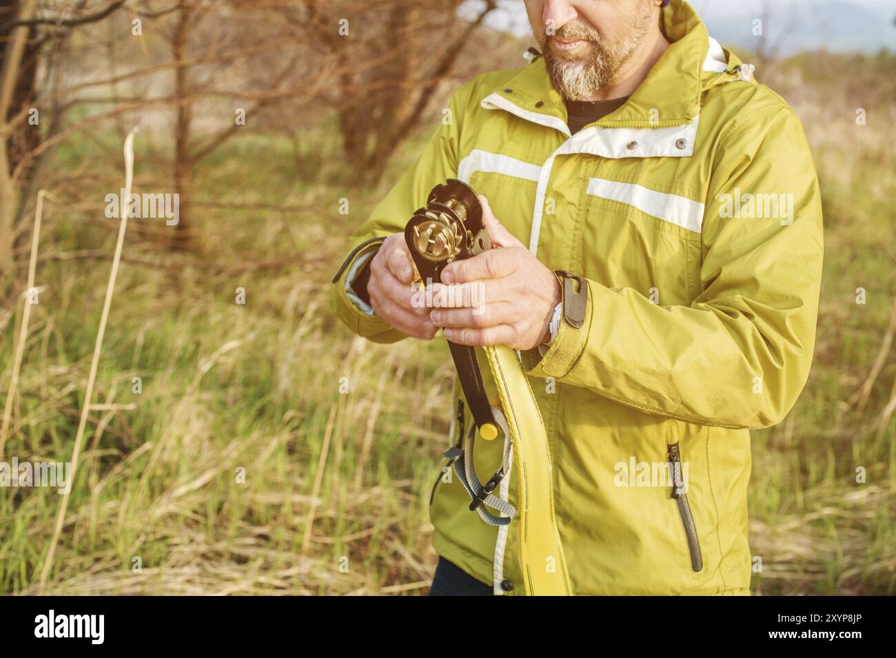 Primo piano, Un uomo regola il livello di gioco dell'attrezzatura prima di eseguire strani trucchi e camminare su un piano in un parco nella natura Foto Stock