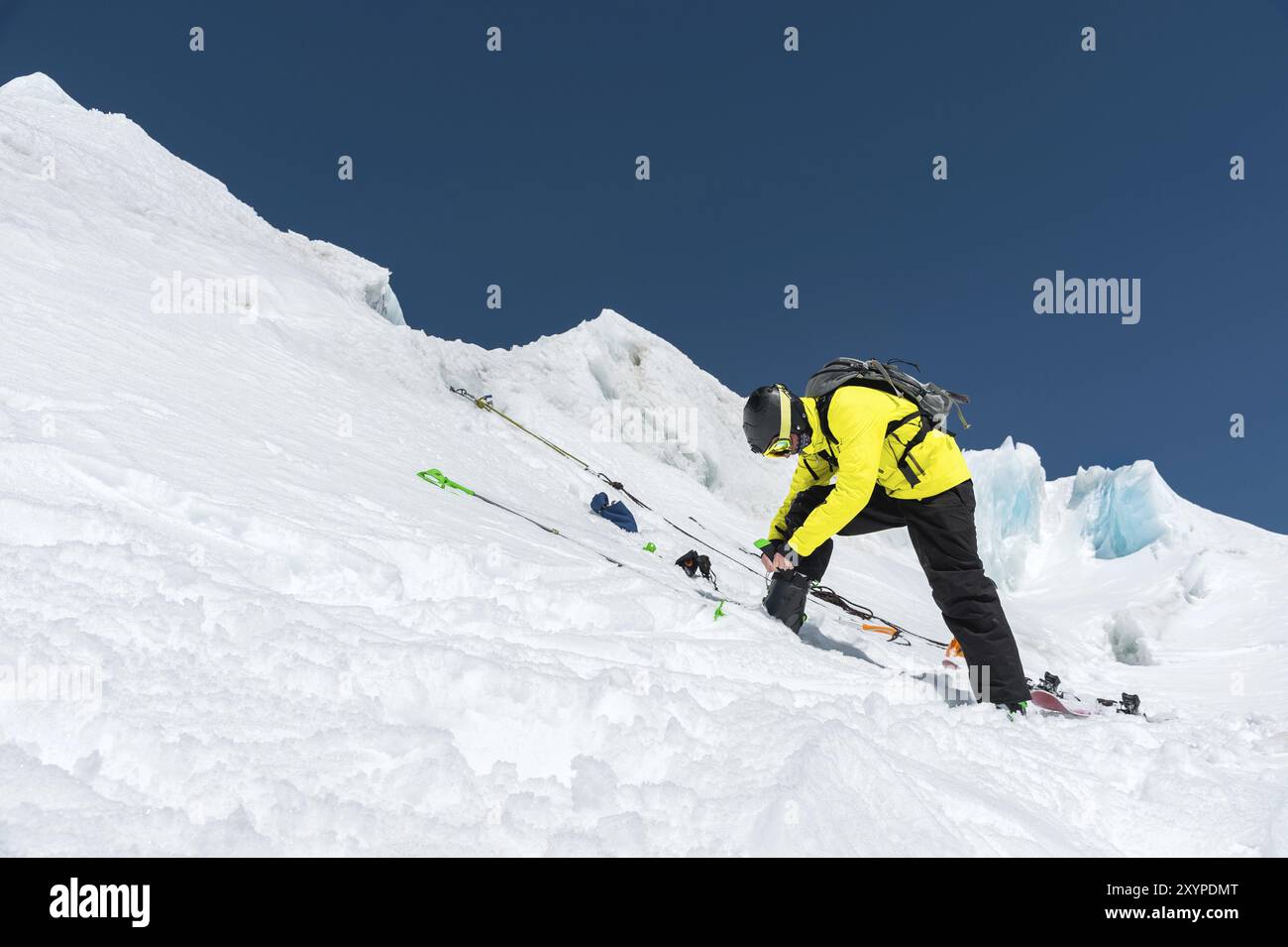 Uno sciatore professionista in piedi su un ghiacciaio si sta preparando per un salto mentre prepara l'attrezzatura da sci. Il concetto di formazione di qualità per lo sport Foto Stock